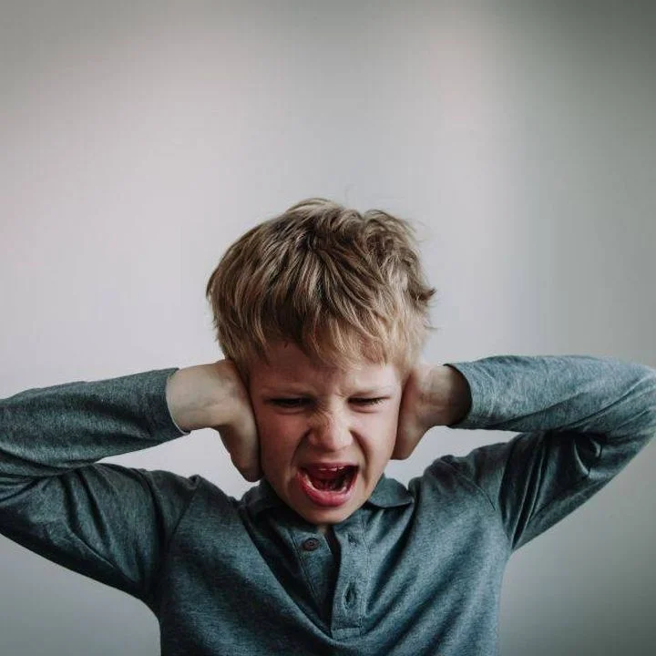 Positive handling - child covering ears with hands and shouting