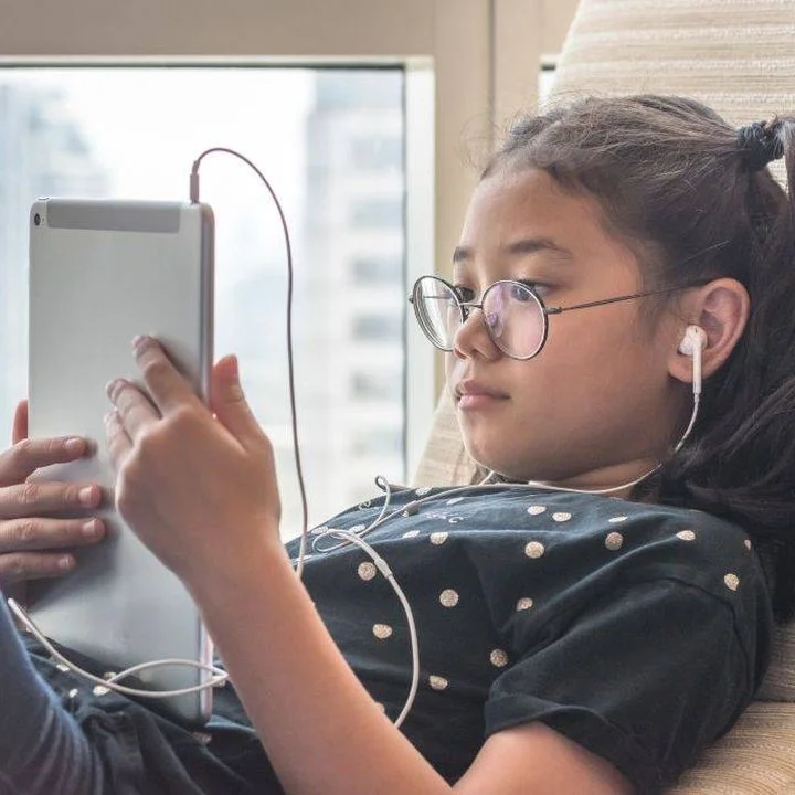 The role of the DSL in promoting online safety - child using a tablet to watch content online